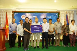 Đại diện các thương binh, gia đình thân nhân liệt sỹ và có công với cách mạng nhận quà từ đại diện Công đoàn BIDV. (Ảnh: Trần Ngọc Long/TTXVN)