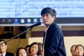 Bị cáo Nguyễn Thanh Hóa xem các văn bản là tang vật của vụ án được chiếu trên màn hình. (Ảnh: Trung Kiên/TTXVN)