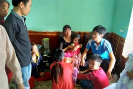 Cháu bé Phạm Mai Nga (đang uống sữa) được giải cứu khỏi sự khống chế của đối tượng Phạm Ngọc Hậu. (Ảnh: TTXVN phát)