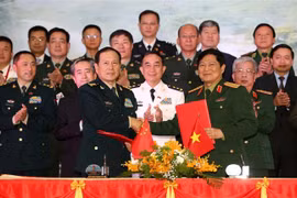 Đại tướng Ngô Xuân Lịch và Thượng tướng Ngụy Phượng Hòa ký Biên bản giao lưu. (Ảnh: Dương Giang/TTXVN)