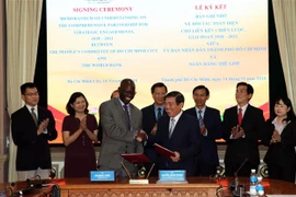 Ông Nguyễn Thành Phong, Chủ tịch UBND thành phố Hồ Chí Minh (phải) và ông Ousmane Dione, Giám đốc WB tại Việt Nam (trái) cùng ký Bản ghi nhớ về đối tác toàn diện giữa thành phố Hồ Chí Minh và WB giai đoạn 2018-2020. (Ảnh: Xuân Khu/TTXVN)