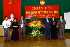Đồng chí Trần Quốc Vượng tặng hoa chúc mừng cán bộ và nhân dân xã Kim Bình. (Ảnh: Quang Cường/TTXVN)