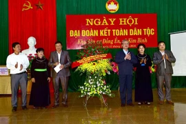 Đồng chí Trần Quốc Vượng tặng hoa chúc mừng cán bộ và nhân dân xã Kim Bình. (Ảnh: Quang Cường/TTXVN)