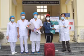Giám đốc Bệnh viện Đa khoa huyện Nho Quan tặng hoa cho bệnh nhân 229 trong ngày xuất viện. (Ảnh: Thùy Dung/TTXVN)