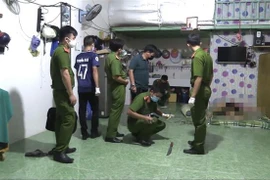 Lực lượng chức năng thu thập thông tin tại hiện trường vụ án. (Ảnh: Nguyễn Văn Việt/TTXVN)