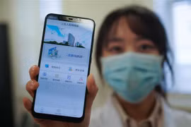 Nhân viên y tế bệnh viện ở Nam Kinh, tỉnh Giang Tô (Trung Quốc) giới thiệu trang mạng tư vấn trực tuyến sơ bộ về virus corona chủng mới (COVID-19). (Ảnh: THX/TTXVN)