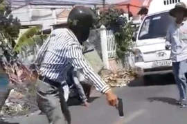 Ông Huỳnh Văn Đài cầm vật nghi là súng đe dọa người va chạm giao thông với ông. (Ảnh: TTXVN phát)