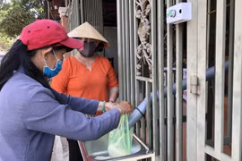 Người dân đến lấy gạo miễn phí tại cây ATM gạo nghĩa tình ở thành phố Long Khánh, Đồng Nai. (Ảnh: Lê Xuân/TTXVN)