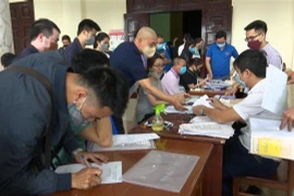 Tình trạng tập trung đông người khi doanh nghiệp và chủ xe tại khu vực xin cấp Giấy xác nhận. (Ảnh: Hoàng Ngọc/TTXVN)