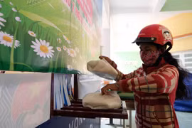 Người dân nhận gạo từ 'ATM gạo' tại thị trấn Khánh Vĩnh (huyện Khánh Vĩnh, Khánh Hoà) trong ngày 25/4. (Ảnh: Nguyễn Dũng/TTXVN)