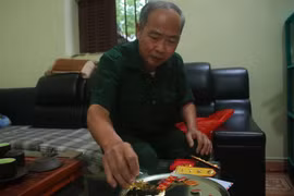  Cựu chiến binh Trần Đức Hòa bên những kỷ vật từ thời kháng chiến chống Mỹ cứu nước. (Ảnh: Chu Hiệu/TTXVN)