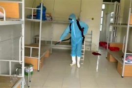 Nhân viên y tế phun thuốc khử khuẩn lại phòng của người bị cách ly. (Ảnh: Nguyễn Nam/TTXVN)
