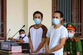 Hai bị cáo Minh và Giàu tại phiên tòa. (Ảnh: Thanh Liêm/TTXVN)