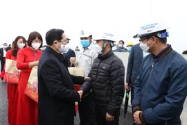 Thủ tướng Phạm Minh Chính chúc Tết kỹ sư, công nhân đang thi công tuyến đường cao tốc Vân Đồn- Móng Cái. (Ảnh: Dương Giang/TTXVN)