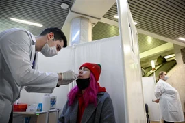 Nhân viên y tế lấy mẫu xét nghiệm COVID-19 cho người dân tại Moskva, Nga ngày 11/10/2021. (Ảnh: AFP/TTXVN)