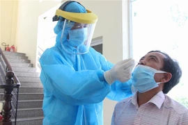 Lấy mẫu xét nghiệm COVID-19 tại Hậu Giang. (Ảnh: Hồng Thái/TTXVN)