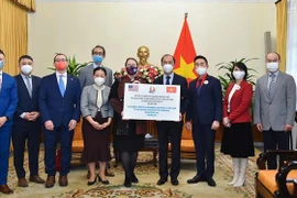 Thứ trưởng Bộ Ngoại giao Nguyễn Quốc Dũng trao số tiền ủng hộ các gia đình có người thân bị thiệt mạng trong các trận bão lốc xảy ra vào tháng 12/2021 tại bang Kentucky, Hoa Kỳ. (Ảnh: TTXVN phát)