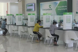 Khách hàng giao dịch tại Ngân hàng TMCP Ngoại thương Việt Nam chi nhánh tỉnh Kon Tum. (Ảnh: Dư Toán/TTXVN)