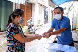 Người dân có hoàn cảnh khó khăn phường 12, Quận 3, TP.HCM nhận hỗ trợ đợt 3. (Ảnh: Thanh Vũ/TTXVN)
