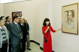 Các đại biểu xem triển lãm hình ảnh và hiện vật trưng bày tại hội nghị. (Ảnh: Nguyễn Dân/TTXVN) 