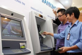 Khách hàng rút tiền tại một điểm giao dịch ATM trên địa bàn Hà Nội. (Ảnh: Trần Việt/TTXVN)