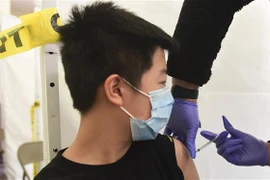 Nhân viên y tế tiêm vaccine phòng COVID-19 cho trẻ em tại Los Angeles, California, Mỹ. (Ảnh: AFP/TTXVN)