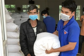 Người dân nhận gạo hỗ trợ của Chính phủ. (Ảnh: Hưng Thịnh/TTXVN)