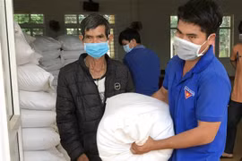 Người dân nhận gạo hỗ trợ của Chính phủ. (Ảnh: Hưng Thịnh/TTXVN)