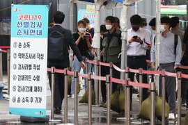 Người dân chờ xét nghiệm COVID-19 tại một điểm xét nghiệm ở Seoul, Hàn Quốc. (Ảnh: YONHAP/TTXVN)