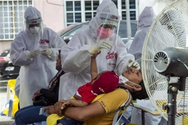 Nhân viên y tế lấy mẫu xét nghiệm COVID-19 cho người dân tại Selangor, Malaysia. (Ảnh: THX/TTXVN)