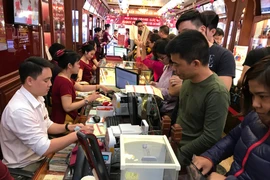 Khách hàng giao dịch vàng tại thị trường Hà Nội. (Ảnh: Đức Duy/Vietnam+)