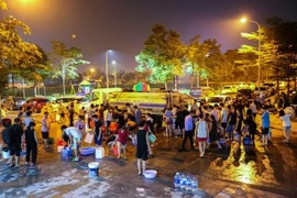 Người dân một số nơi xếp hàng lấy nước sạch. (Ảnh: PV/Vietnam+)