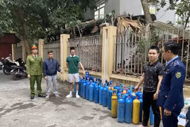 Lực lượng chức năng thu giữ hàng chục bình khí cười trên địa bàn huyện Gia Lâm. (Ảnh: PV/Vietnam+)