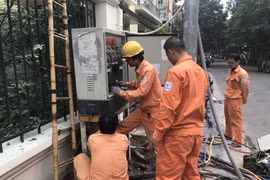 Nhân viên EVNHANOI kiểm tra vận hành thiết bị điện. (Ảnh: Xuân Quảng/Vietnam+)