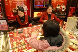 Khách hàng giao dịch tại cửa hàng vàng. (Ảnh: Minh Hiếu/Vietnam+) 
