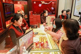 Khách hàng giao dịch vàng tại thị trường Hà Nội ngày Thần Tài. (Ảnh: Minh Hiếu/Vietnam+)