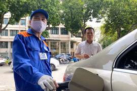 Nhân viên Petrolimex đang bán xăng cho khách hàng. (Ảnh: Đức Duy/Vietnam+)