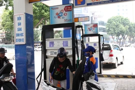 Nhân viên Petrolimex bán xăng cho khách hàng. (Ảnh: Đức Duy/Vietnam+)