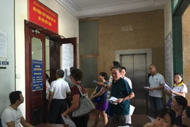 Rất đông người dân do lo sợ xử phạt khi không đổi giấy phép lái xe từ vật liệu giấy sang vật liệu PET nên đã cấp tốc đi đổi. (Ảnh: Việt Hùng/Vietnam+)