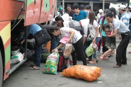 Hành khách trở về Thủ đô với hành trình mệt nhoài vì bị nhồi và chặt chém giá vé. (Ảnh: Việt Hùng/Vietnam+)