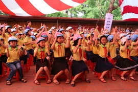 Học sinh đội mũ bảo hiểm đạt chuẩn để đảm bảo an toàn giao thông. (Ảnh: Việt Hùng/Vietnam+)