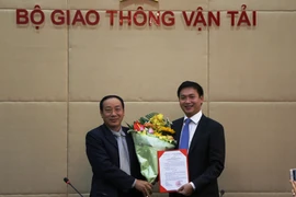 Thứ trưởng Nguyễn Hồng Trường trao hoa và quyết định bổ nhiệm cho ông Nguyễn Xuân Ảnh. (Ảnh: Minh Phương/Vietnam+) 