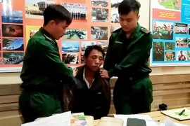 Đối tượng bị bắt cùng tang vật tại cơ quan chức năng. (Ảnh: TTXVN phát)