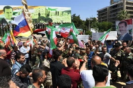 Người dân Syria đổ xuống đường phố Aleppo bày tỏ sự ủng hộ Tổng thống Bashar al-Assad và quân đội Chính phủ. (Nguồn: AFP/TTXVN)