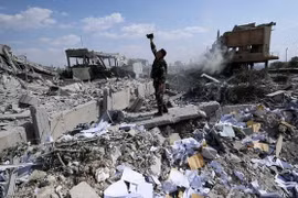 Một người lính Syria chụp ảnh tại đống đổ nát ở Trung tâm nghiên cứu khoa học gần Damascus (Nguồn: AP)