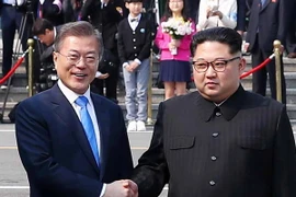 Tổng thống Hàn Quốc Moon Jae-in (trái) bắt tay hữu nghị Nhà lãnh đạo Triều Tiên Kim Jong-un (phải) tại làng đình chiến Panmunjom. (Nguồn: YONHAP/TTXVN)