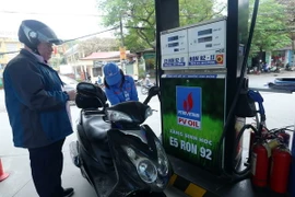 Khách hàng mua xăng E5. (Ảnh: Huy Hùng/TTXVN)