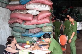 Lực lượng chức năng làm việc với chủ cơ sở sản xuất càphê bẩn. (Ảnh: TTXVN phát)
