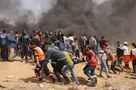 Chuyển người bị thương trong xung đột giữa người biểu tình Palestine và binh sỹ Israel phía Đông khu vực biên giới giữa Dải Gaza và Israel. (Nguồn: AFP/TTXVN)