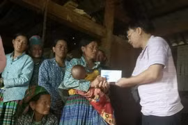 Lãnh đạo huyện Sốp Cộp động viên, hỗ trợ gia đình các nạn nhân. (Ảnh: Nguyễn Chiến/TTXVN)